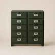 Green metal cabinet with multiple drawers on a beige background