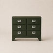Green dresser with six drawers on a beige background
