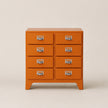 Orange dresser with six drawers on a beige background