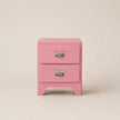 Pink two-drawer nightstand with silver handles on a beige background