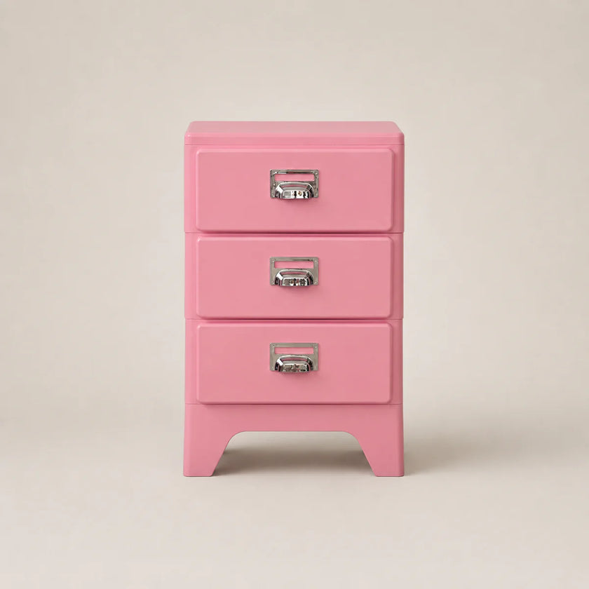 Pink three-drawer jewelry box with silver handles on a beige background