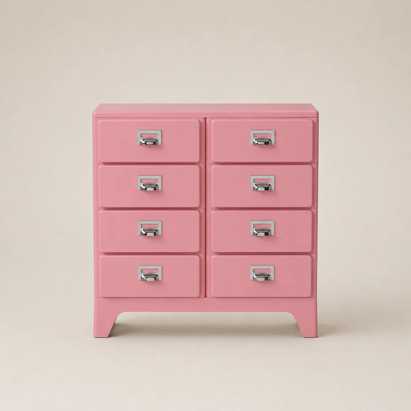 Pink dresser with multiple drawers on a beige background