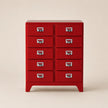 Red metal chest of drawers with multiple drawers on a beige background
