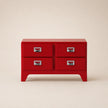 Red dresser with four drawers on a beige background