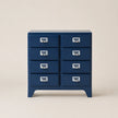 Blue dresser with multiple drawers on a beige background