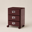 Brown file cabinet with three drawers on wheels against a beige background