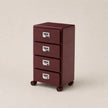 Red metal file cabinet with three drawers on a beige background