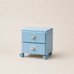 Light blue jewelry box with two drawers on wheels against a beige background