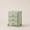 Light green three-drawer filing cabinet on wheels with metallic handles against a beige background