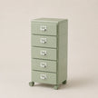 Green metal file cabinet with four drawers on wheels against a beige background
