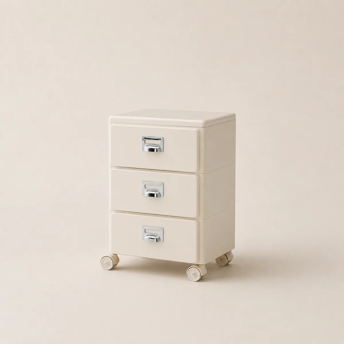 Beige three-drawer filing cabinet on wheels with metallic handles against a beige background