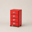 Red three-drawer filing cabinet on wheels with labels on a beige background