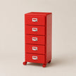 Red metal file cabinet with four drawers on a beige background
