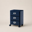 Navy blue three-drawer filing cabinet on wheels with metallic handles against a beige background