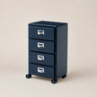Navy blue file cabinet with four drawers on wheels against a beige background
