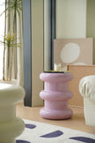 Pink plastic step stool in a living room setting with a plant and furniture.