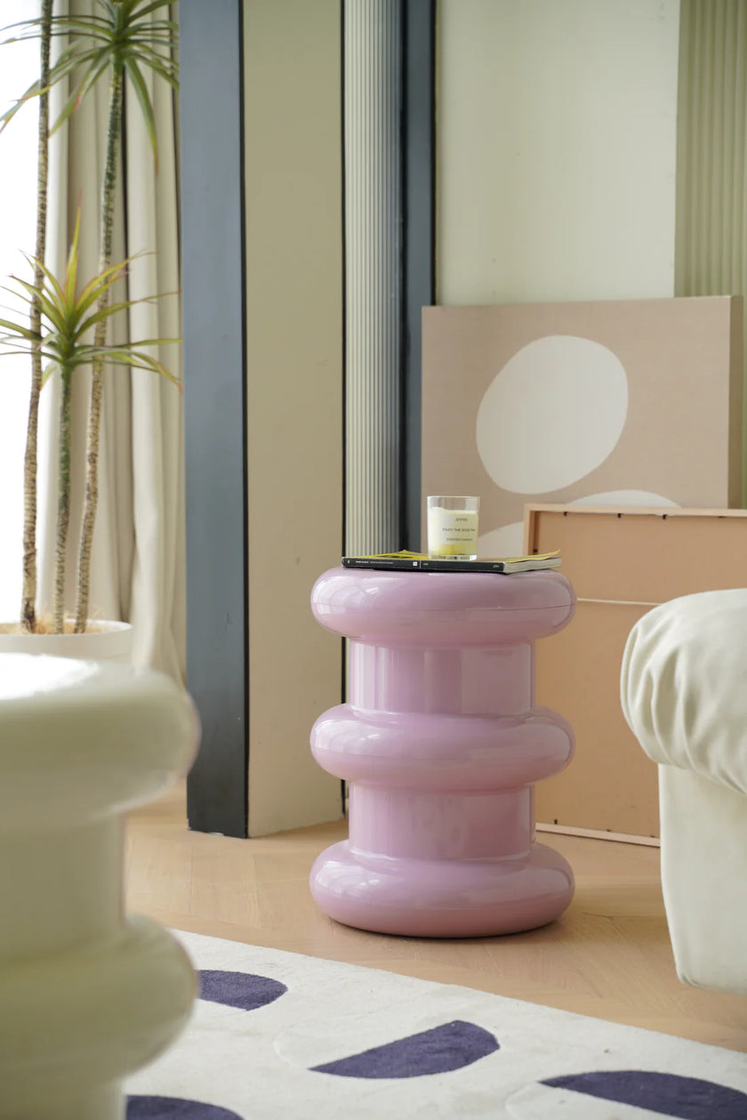 Pink plastic step stool in a living room setting with a plant and furniture.