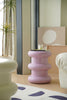 Pink plastic step stool in a living room setting with a plant and furniture.