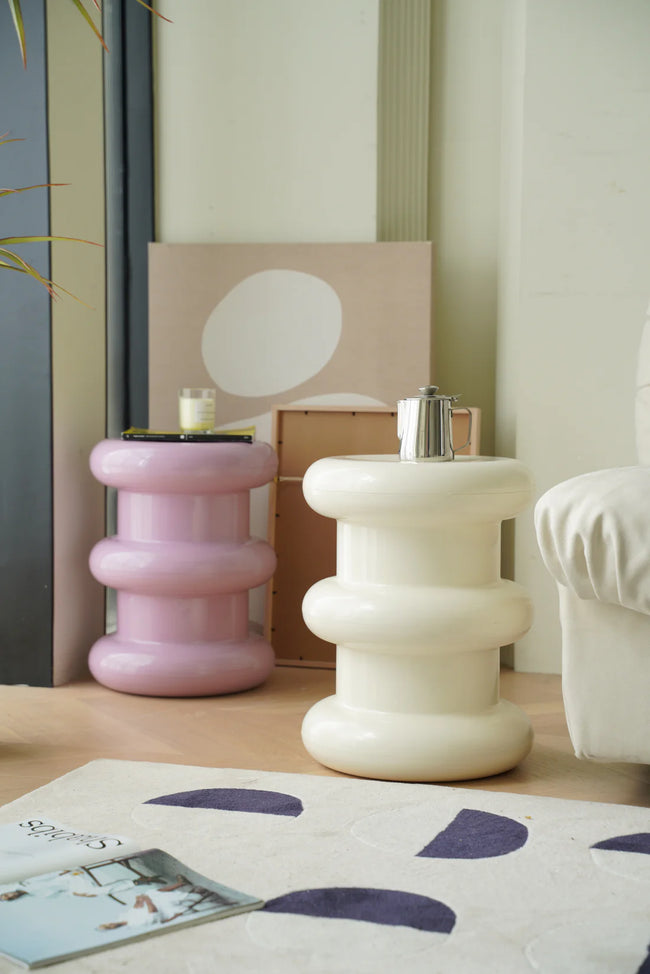 Two colorful plastic step stool in a living room setting with a magazine on a rug.