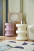 Two colorful plastic step stool in a living room setting with a magazine on a rug.