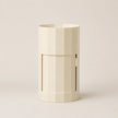 Beige cylindrical container with a handle on a light beige background