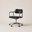 Black office chair with chrome base on a beige background