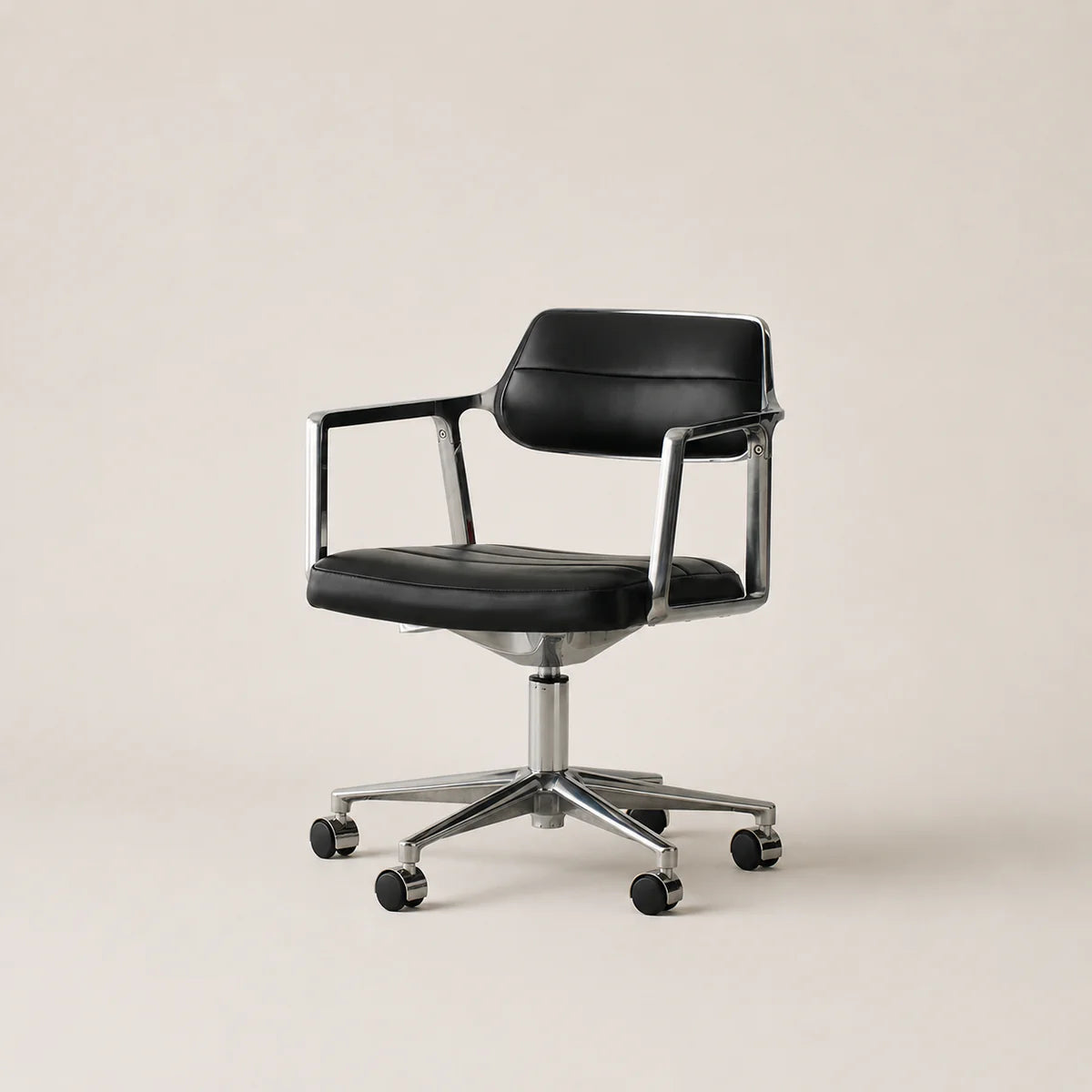 Black office chair with chrome base on a beige background