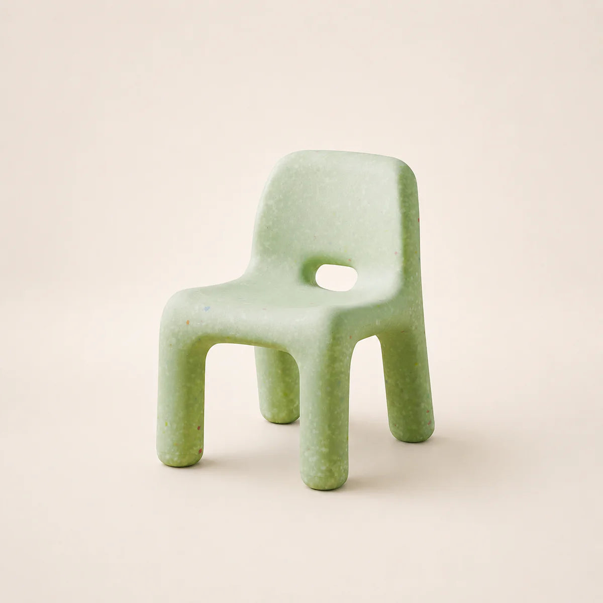 Green plastic chair on a beige background