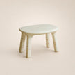 Small round table with a textured surface on a plain background