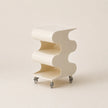 Modern white side table with wavy design on a beige background