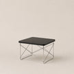 Small black table with metal frame on a beige background