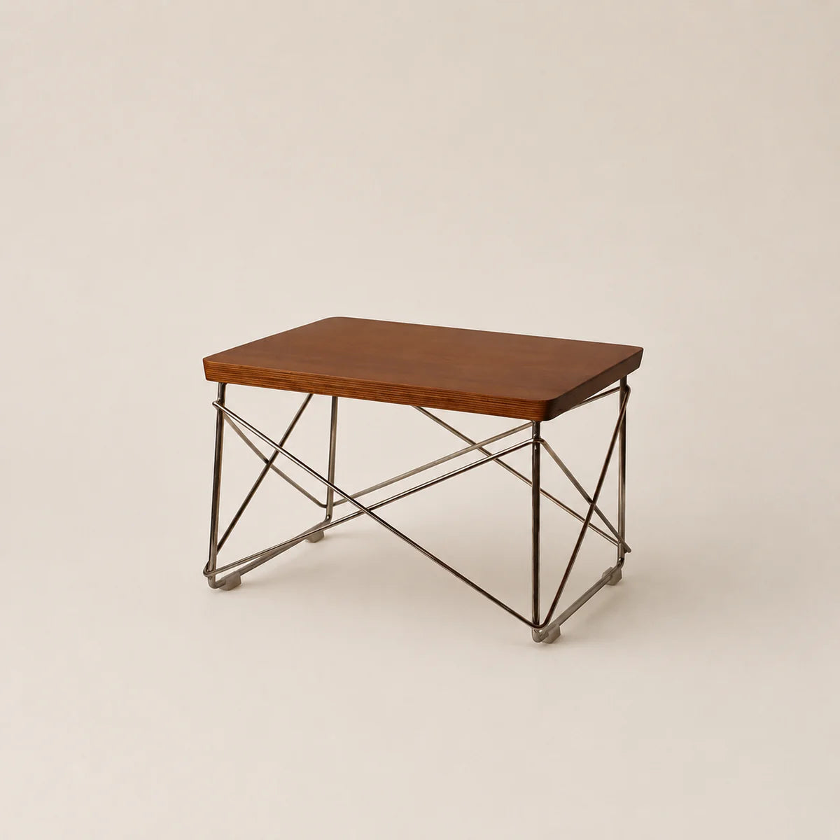 Small wooden table with metal legs on a beige background