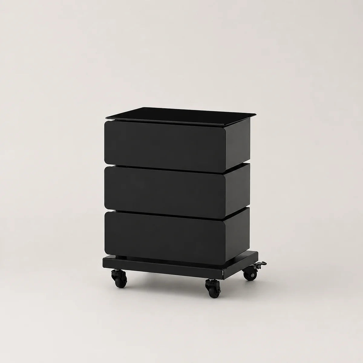 A black three-drawer storage cart with a rectangular top and four caster wheels, photographed on a clean light gray studio background.