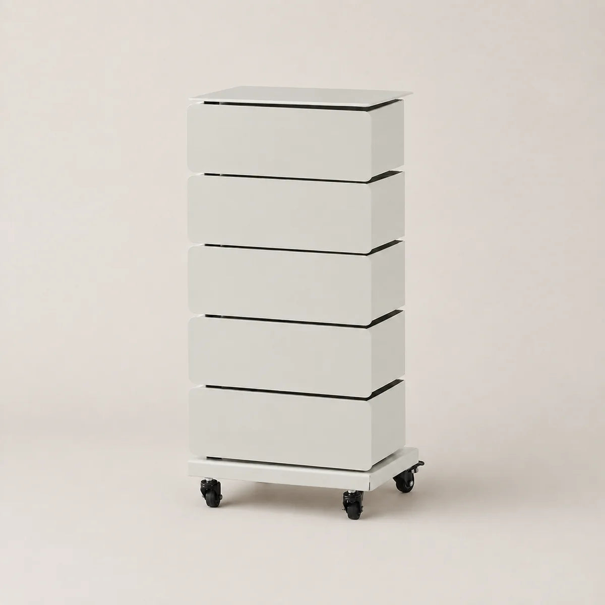 A tall, narrow five-drawer storage cabinet in white with black accents, featuring a flat top and caster wheels at the base, photographed against a plain light beige studio background.