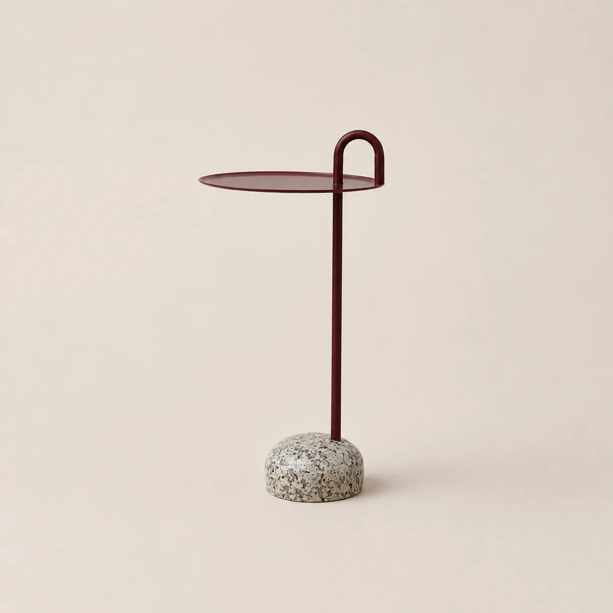 Small side table with a round top and textured base on a beige background