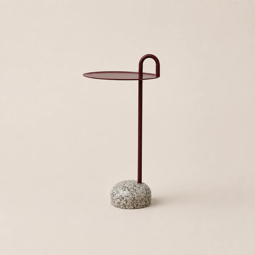 Small side table with a round top and textured base on a beige background