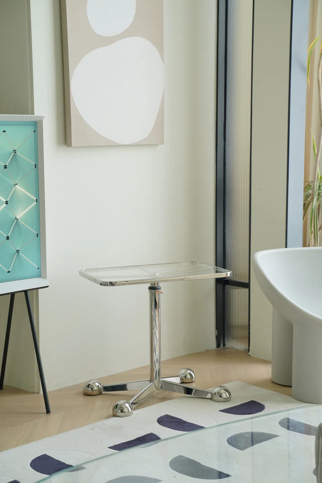 Modern living room interior with a side table rolling cart sink, stool, and abstract art on the wall.
