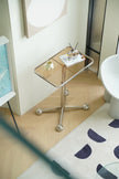 Small glass side tables living room with a metallic base on a wooden floor next to a white cabinet.