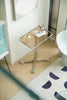 Small glass side tables living room with a metallic base on a wooden floor next to a white cabinet.