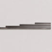 Four metallic silver rods of varying lengths arranged in a stepped horizontal layout against a plain light gray background.