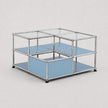 A modular two-tier storage organizer with a chrome metal frame, clear glass top panels, and light blue shelves, shown on a neutral light gray background.