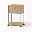 A modern two-tier storage cabinet with a silver chrome tubular metal frame and beige metal panels, featuring a single upper drawer with a silver lock and a lower open shelf.