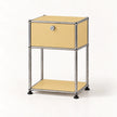 A modern two-tier nightstand with a goose yellow laminate finish and a chrome tubular metal frame, featuring a single drawer with a lock and a lower open shelf.