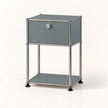 A modern two-tier storage cabinet with a gray panel front and a silver metal frame, featuring a single lockable drawer on the top shelf and a lower open shelf, set against a plain white background.