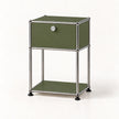 An olive green modular storage cabinet with a silver metal frame, featuring a top drawer with a round silver knob and a lower open shelf, set against a plain white background.