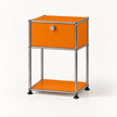 An orange and chrome modular side table with a single drawer and a lower shelf, photographed on a clean white background.