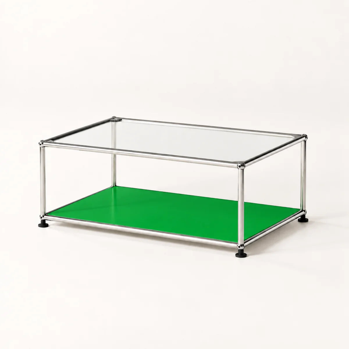 A modern modular coffee table with a clear glass top, a bright green lower shelf, and a stainless metal frame with black feet, shown on a clean white background.