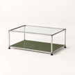 A modern two-tier coffee table with a clear glass top, a stainless metal frame, and an olive green lower shelf, shown on a plain light background.