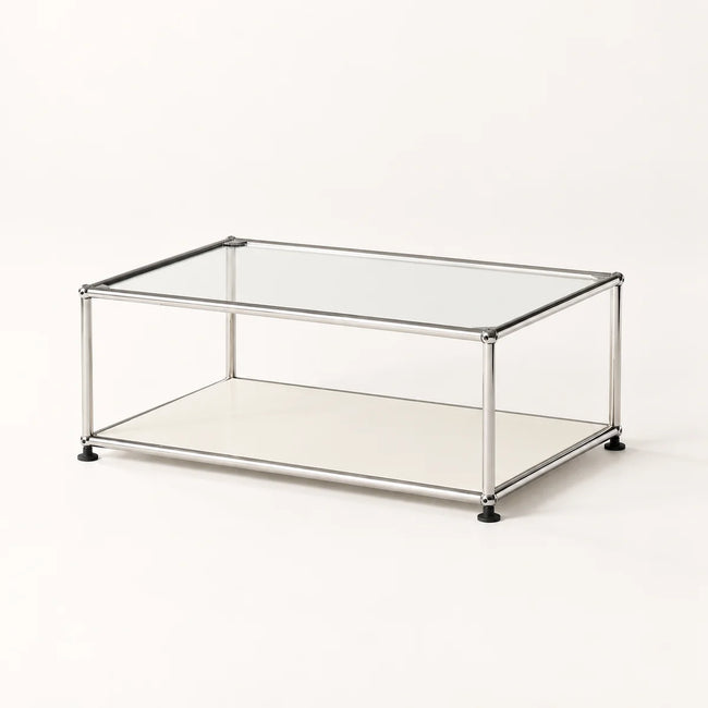 A modern rectangular coffee table with a clear glass top, a lower metal shelf, and a slim stainless metal frame with black feet, shown on a clean white background.