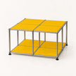 A modular cube storage organizer with a chrome metal frame and bright yellow panels on the top and bottom shelves, set against a plain white background.